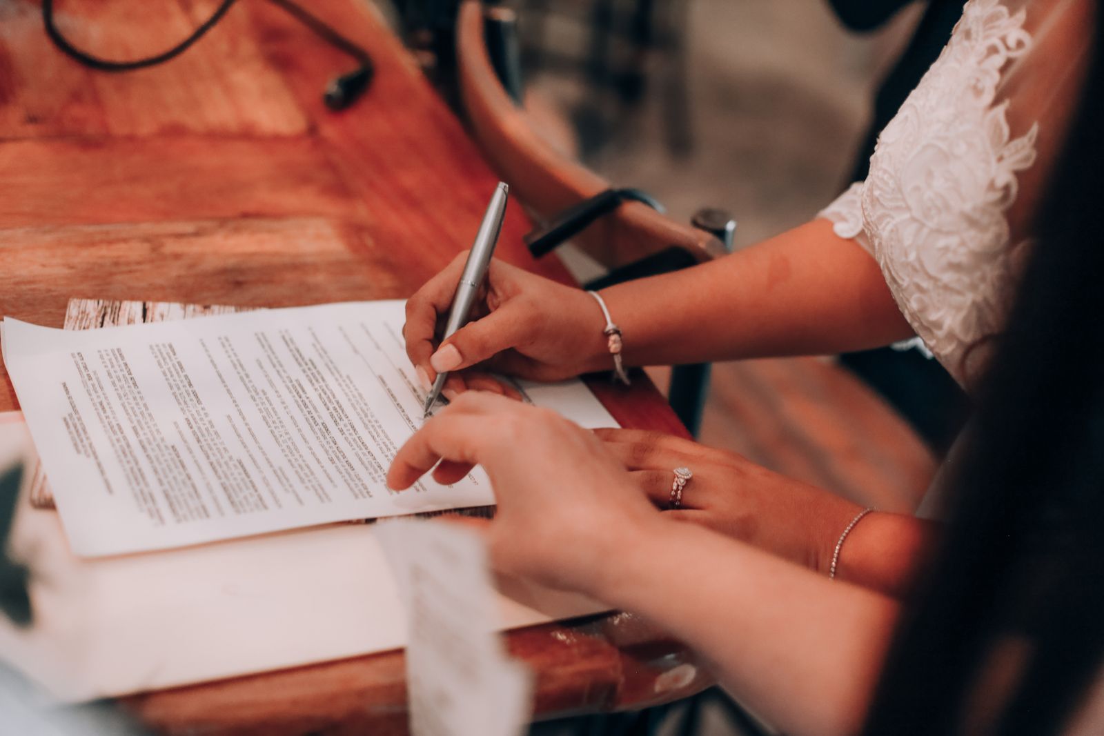 Borrower signing mortgage closing documents at a wooden table